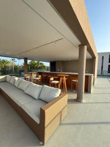 a couch on a patio with a table and chairs at Malia Beach Muro Alto 300 Metros Do Mar in Porto De Galinhas