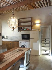 a kitchen with a table and a white refrigerator at Le LOFT LOURMARIN in Lourmarin +14 photos