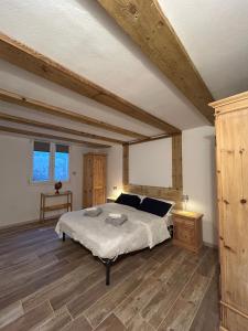une chambre avec un grand lit et un parquet dans l'établissement Casa Sally - Lago e montagna, à Cresciasca