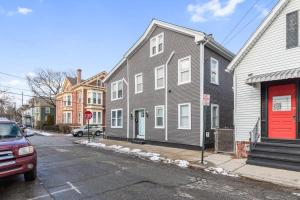 a gray house with a red door on a street at Federal Hill PRIDE in Providence