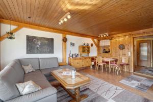 una sala de estar con un sofá y una mesa en Haus Hölltalblick, en Schönwald
