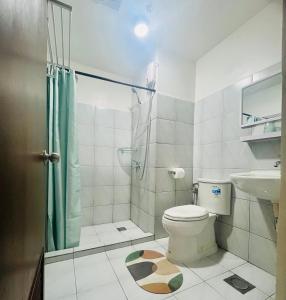 a bathroom with a shower and a toilet and a sink at Aizen's haven at Casa Mira Guadalupe in Cebu City