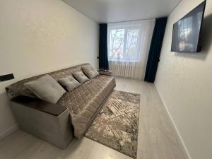 a living room with a couch and a window at Tatiana apartment in Chişinău