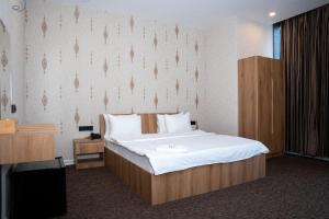 een slaapkamer met een groot bed en een tv bij Royal Bakrajo Hotel in As Sulaymānīyah