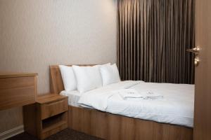 een slaapkamer met een bed met twee handdoeken erop bij Royal Bakrajo Hotel in As Sulaymānīyah