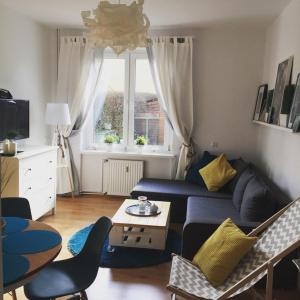 a living room with a blue couch and a table at Apartament Kapitański Władysławowo in Władysławowo
