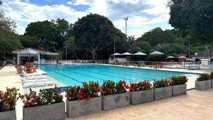 a large swimming pool with red flowers in front of it at Club Campestre de Neiva in Neiva