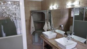 a bathroom with two sinks and a large mirror at Avondale in Richards Bay