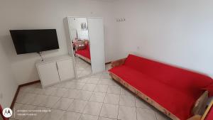 a living room with a red couch and a flat screen tv at Apartman Dinko in Bol