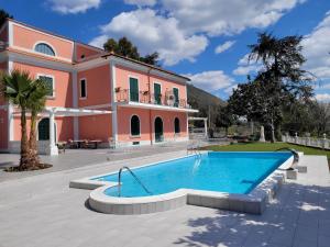 a villa with a swimming pool in front of a house at VILLA ESMERALDA in Salerno