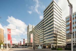 a tall building with many windows on a street at Wembley Stadium Apartments by Sleepy Lodge London in London
