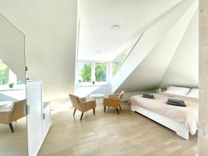 a bedroom with a bed and a desk and chairs at Luxury Central Apartment Easy Kaunas in Kaunas