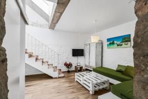 a living room with a green couch and stairs at Casa Bonita Peaceful Home in Ingenio