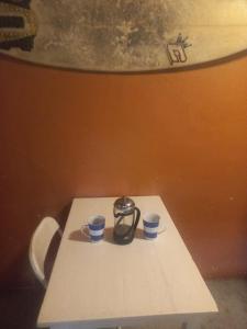 a table with two cups and a tea kettle on it at Top spot for adventurous couple in Fish hoek