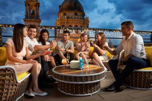 a group of people sitting around a table at Aria Hotel Budapest by Library Hotel Collection in Budapest