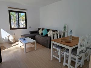 a living room with a couch and a table at Oasis Duna - Casa Mariposa in Corralejo