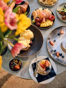 a table topped with plates of food on plates at Aria Hotel Budapest by Library Hotel Collection in Budapest