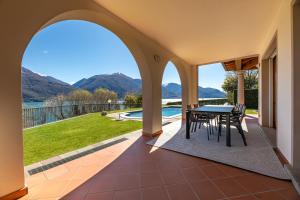 a patio with a table and chairs and a view at Villa Principessa - Private Villa with Panoramic Lake Como Views in Cremia
