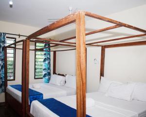 2 literas en una habitación con paredes blancas en Swahili house, en Galu 18 fotos más