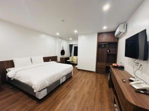 a bedroom with a bed and a desk with a television at X9 Hotel Luxury in Thuong Thon