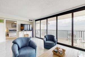 a living room with two chairs and a balcony at Sea Colony - 1505N Edgewater House in Bethany Beach