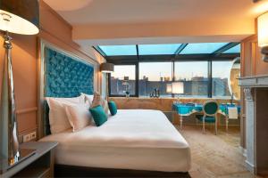 a bedroom with a large bed with a large window at Aria Hotel Budapest by Library Hotel Collection in Budapest +37 photos