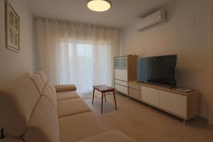 a living room with a couch and a flat screen tv at Nice apartment next to the golf in El Portil