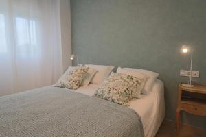 a bedroom with a bed with two pillows on it at Nice apartment next to the golf in El Portil +8 photos