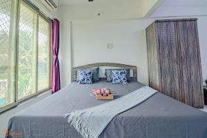 a bedroom with a bed with a basket of flowers on it at THE BLISS PALM in Mumbai +17 photos