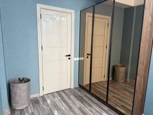 a mirror in a room with a blue wall at Crystal Apartments in Tbilisi City