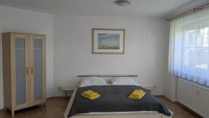 a bedroom with a bed with yellow towels on it at Ferienwohnung mit Garten in der Nähe Landshut in Geisenhausen