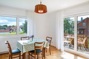 a dining room with a table and chairs and windows at Wildbiene bis 4 Pers in Freiensteinau