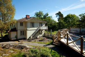 a house with a wooden bridge in front of it at Smådalarö Gård Hotell & Spa in Dalarö