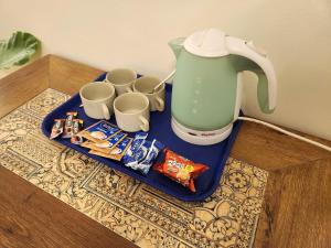 a blue tray with a tea kettle and cups on a table at BeachWalk Tulip Apartments Vagator in Vagator