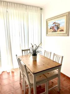 a dining room table with chairs and a potted plant on it at Apartamento a pie de playa en El Portil in El Portil