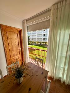 a dining room with a table and a large window at Apartamento a pie de playa en El Portil in El Portil