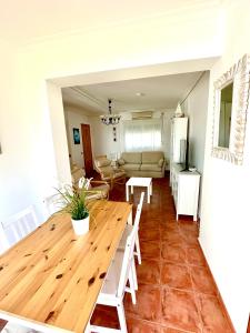 a dining room and living room with a wooden table at Apartamento a pie de playa en El Portil in El Portil