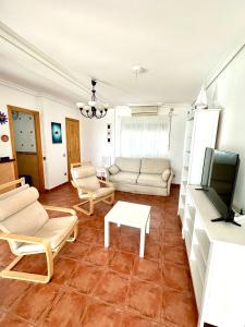 a living room with a couch and a tv at Apartamento a pie de playa en El Portil in El Portil