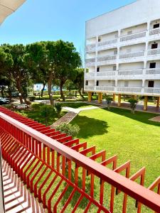 a row of red bleachers in front of a building at Apartamento a pie de playa en El Portil in El Portil