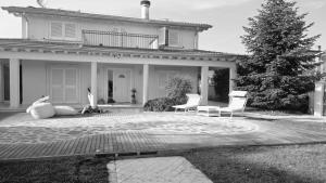 a house with two chairs and a tree in front of it at Villa Concetta in Torre del Lago Puccini +31 photos