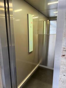 a glass elevator with a sign on the wall at Crystal Apartments in Tbilisi City