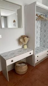 a white cabinet with a mirror and a vase at La Paserina in Arenas de Cabrales
