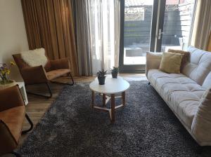 a living room with a couch and a coffee table at Aan't Strand Bed by the Sea Adults only in Westkapelle