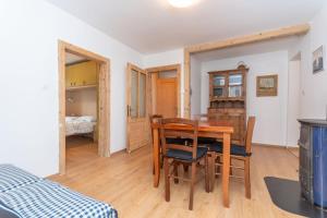 a dining room with a table and chairs and a bedroom at Casa Col di Frena in Falcade