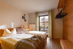 Un dormitorio con una cama grande y una ventana en Almgasthof Grafenherberg, en Oberaudorf