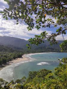 伊利亚贝拉Casa delas Ilhabela的和水中的人一起欣赏海滩的景色