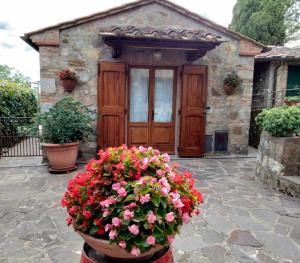 a house with a door with flowers in front of it at La Perla di Borgo Cignano in Vagliagli