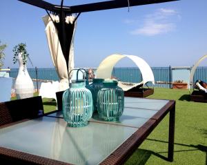 two blue vases sitting on a table under an umbrella at Residence Frontemare in Rimini