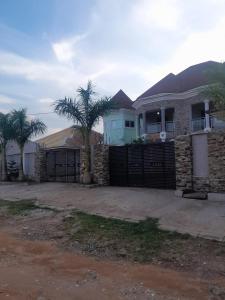 a house with a gate and a palm tree at a home away from home in Trofwi