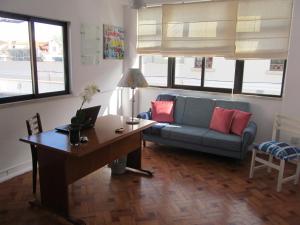 a living room with a couch and a table with a desk at Casa Azul Hostel in Sintra